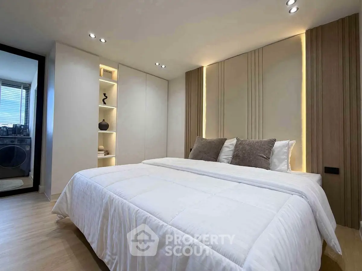 Luxurious bedroom with modern design and ambient lighting, featuring a plush bed and stylish decor.