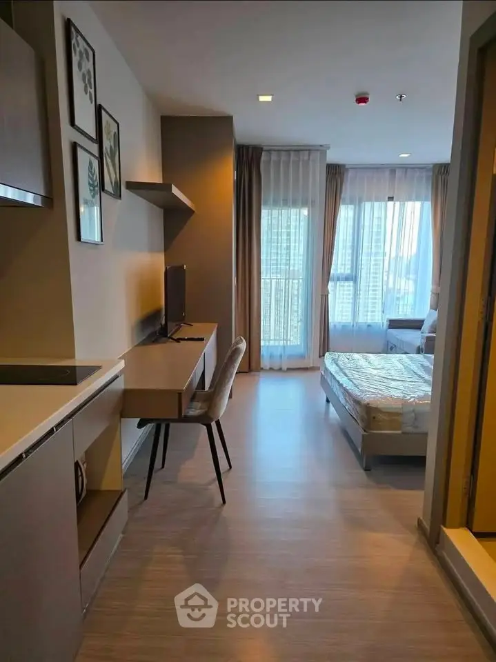 Modern studio apartment with sleek kitchen and cozy bedroom area, featuring large windows for natural light.