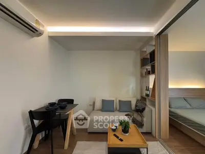 Modern living room with cozy sofa, dining area, and sliding door to bedroom in stylish apartment.