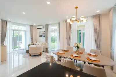Luxurious open-plan living and dining area with elegant decor and natural light.