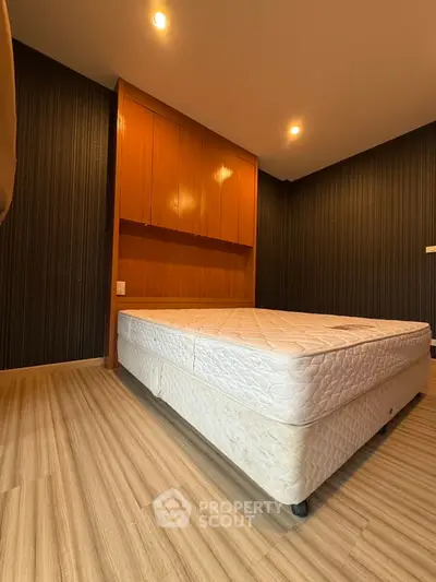 Spacious bedroom with wooden flooring and built-in wardrobe, perfect for modern living.