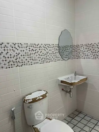 Modern bathroom with mosaic tile accent and compact fixtures for efficient space use.
