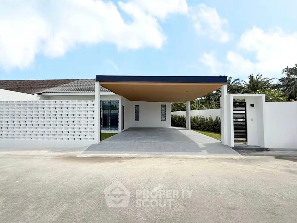 Modern single-story home with spacious carport and minimalist design.