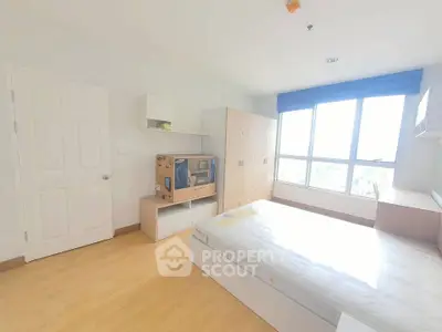 Bright and airy bedroom with large window and modern furnishings in a stylish apartment.