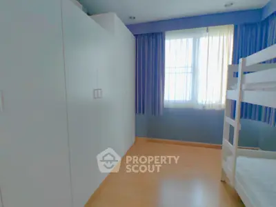 Bright bedroom with bunk bed and large wardrobe, ideal for family living.
