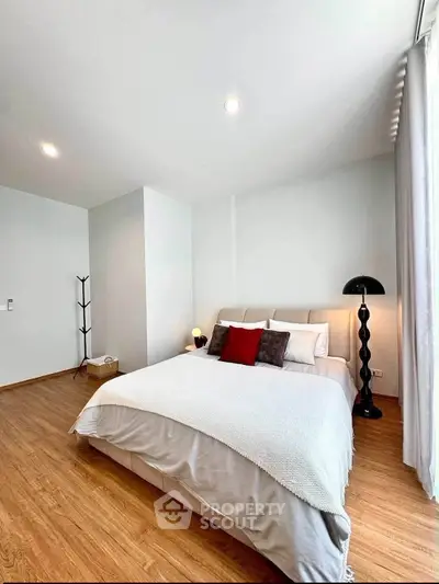 Modern bedroom with cozy decor and stylish lighting in a contemporary apartment.