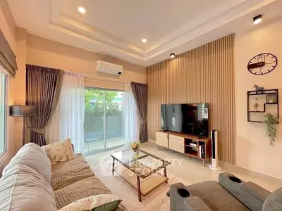 Modern living room with stylish decor, large TV, and cozy seating area.