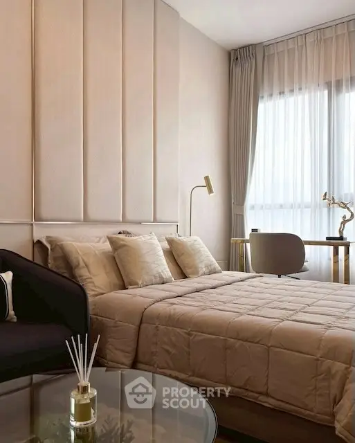 Luxurious bedroom with elegant decor and natural light, featuring a cozy bed and stylish furnishings.