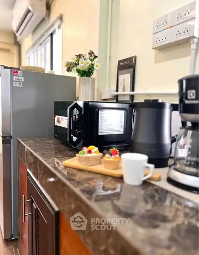 Modern kitchen with marble countertop, microwave, and coffee maker, perfect for culinary enthusiasts.