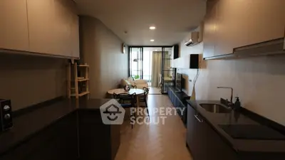 Modern open-layout kitchen and living room with sleek design and cozy seating area.