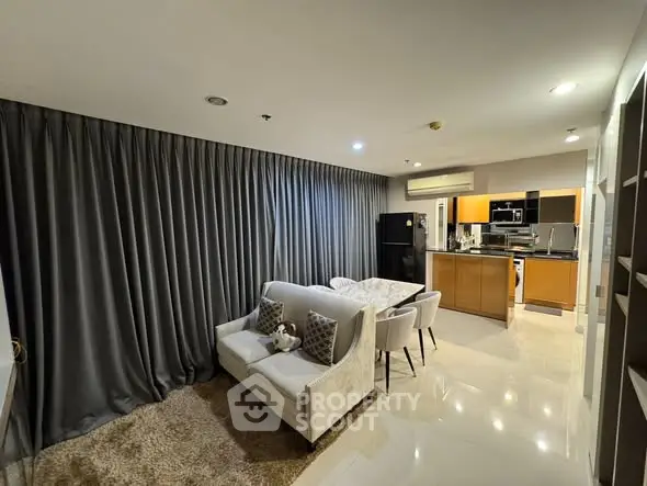 Modern open-plan living room and kitchen with sleek design and cozy ambiance.