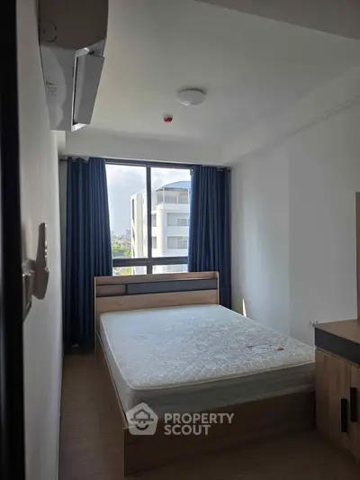 Modern bedroom with large window and natural light in urban apartment
