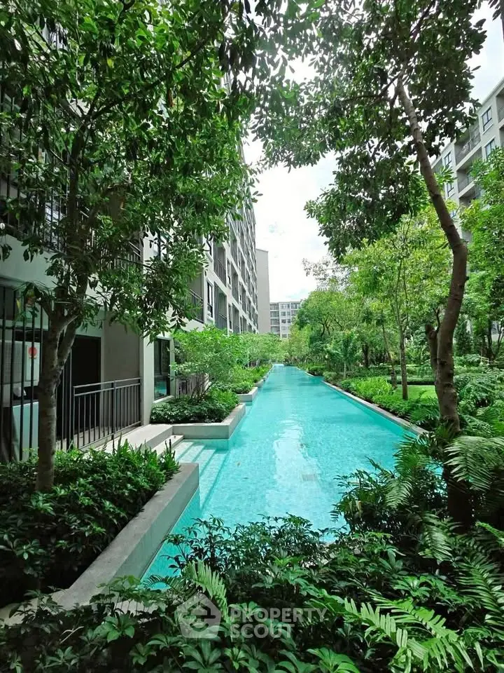 Luxurious residential building with serene pool and lush greenery, perfect for relaxation and leisure.