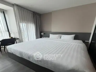 Spacious modern bedroom with large bed and natural light