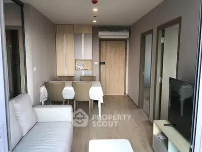 Modern living room with dining area in a stylish apartment, featuring neutral tones and sleek furniture.