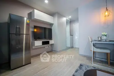 Modern living room with sleek design, featuring a stainless steel fridge and stylish dining area.