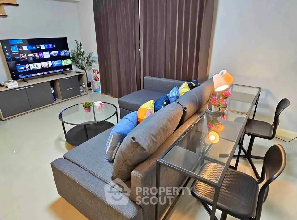 Modern living room with sleek furniture and large TV, perfect for entertainment.