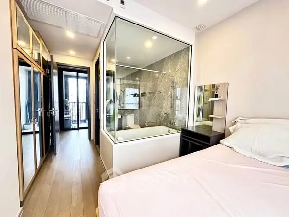 Modern bedroom with glass-enclosed bathroom and sleek design