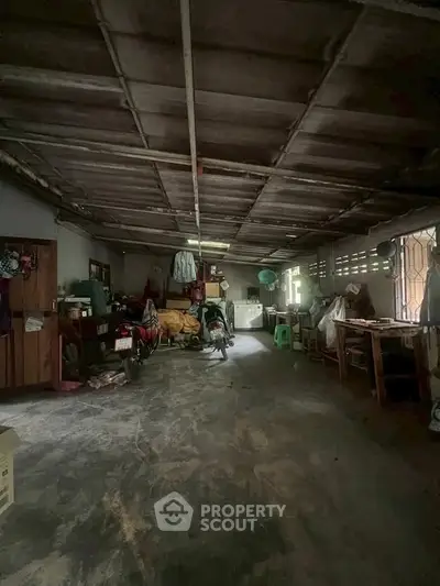 Spacious storage area with ample room for vehicles and belongings, featuring a rustic ceiling and natural light.
