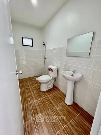 Modern bathroom with wooden floor tiles and white fixtures