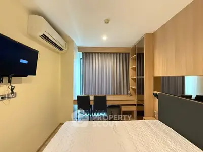 Modern bedroom with built-in desk and shelving, featuring air conditioning and a wall-mounted TV.