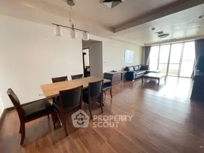 Spacious modern living room with dining area and large windows offering natural light.
