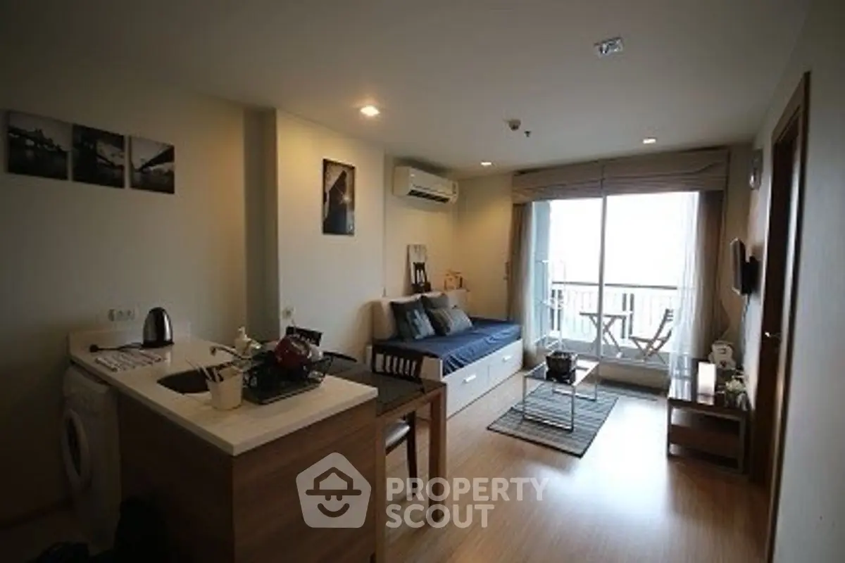 Cozy living room with modern decor and balcony access in urban apartment.
