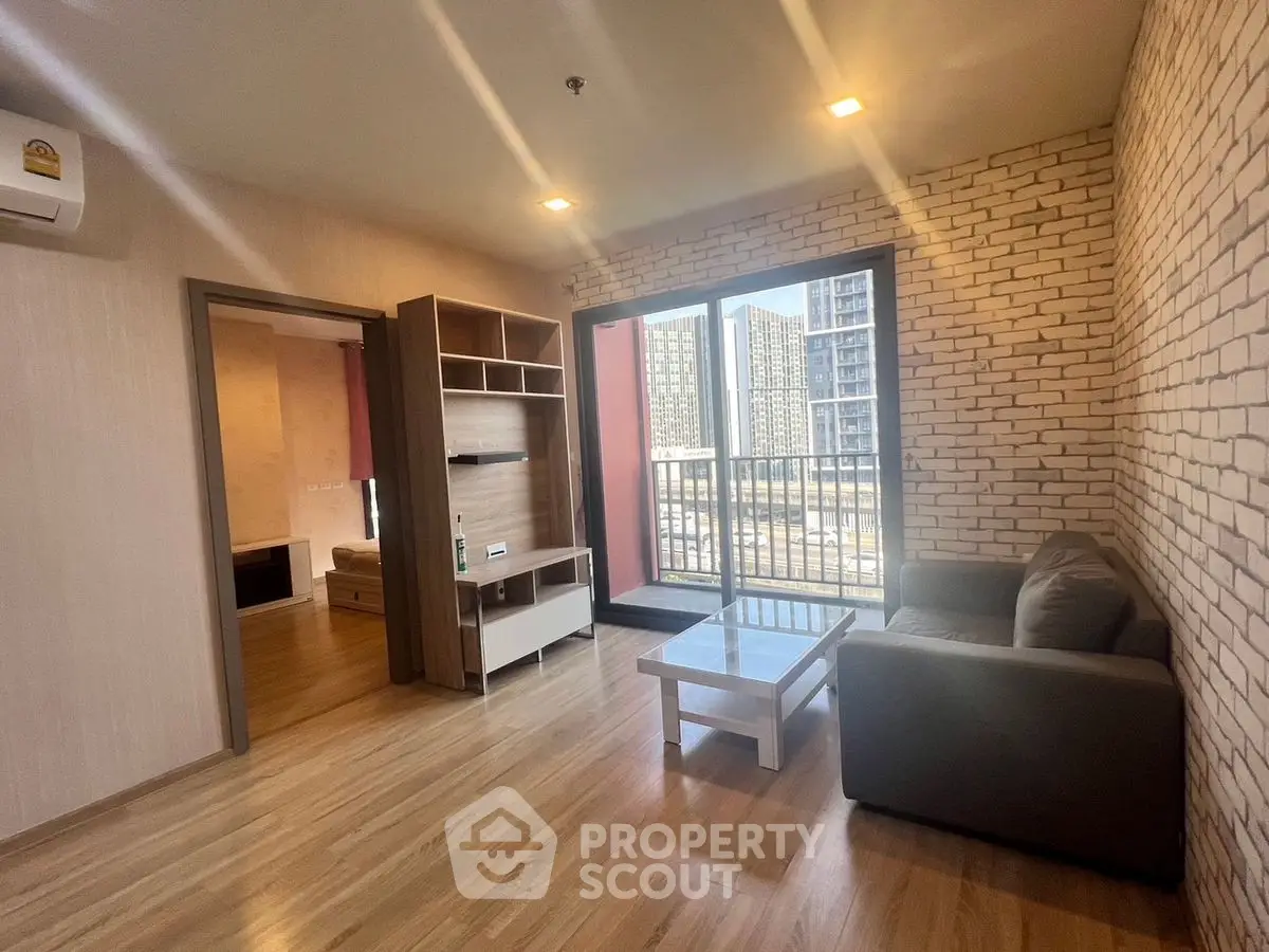 Modern living room with brick accent wall and balcony view in urban apartment