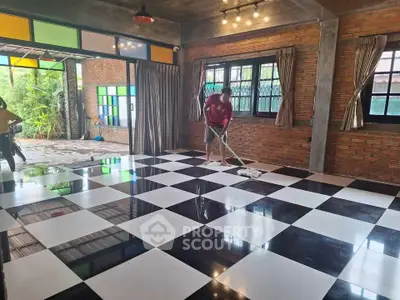 Spacious living room with checkered floor and large windows, perfect for modern living.