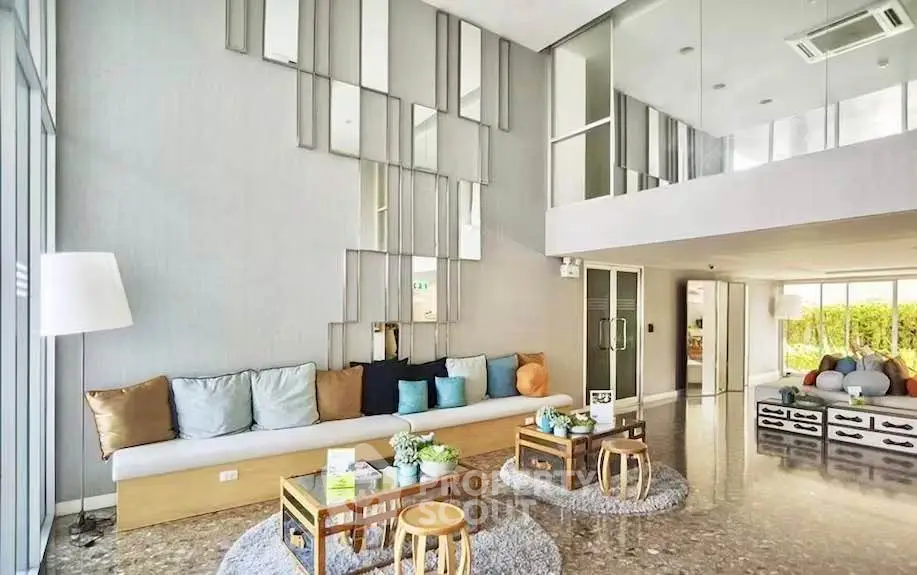 Spacious modern living room with stylish decor and large windows for natural light.
