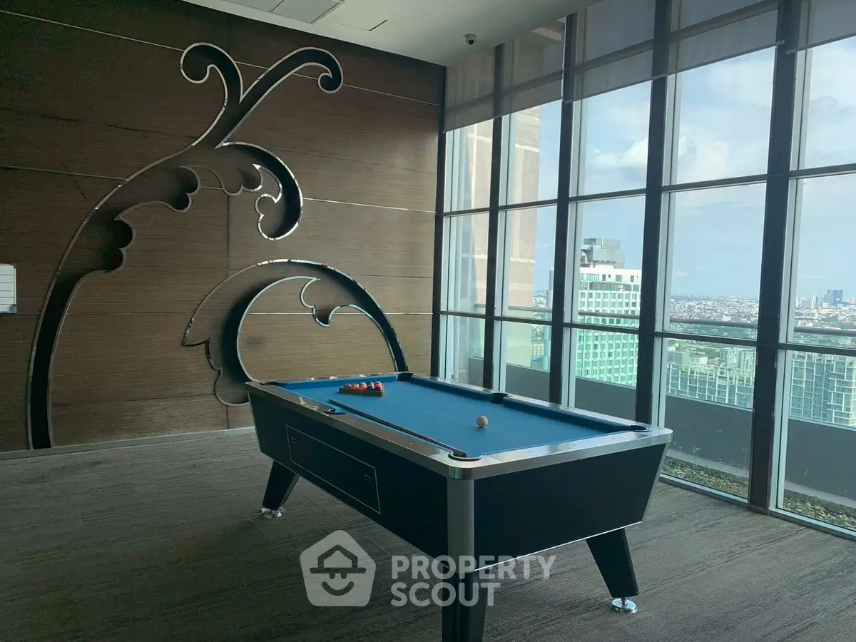 Luxurious high-rise building with a pool table and stunning city view, perfect for entertainment and relaxation.