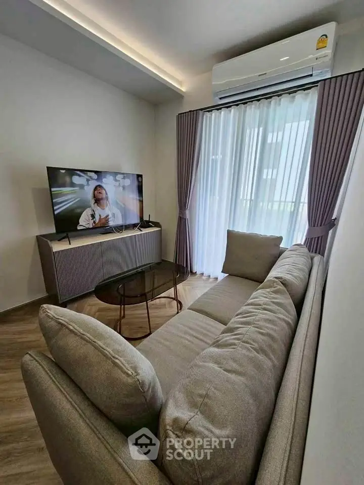 Modern living room with sleek furniture and large window for natural light.