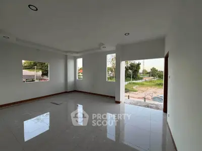 Spacious living room with large windows offering natural light and scenic views, perfect for modern living.