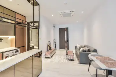 Modern open-plan living room with stylish kitchen and cozy seating area in a contemporary apartment.