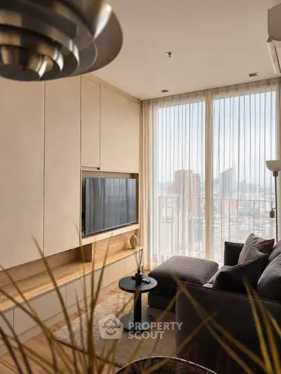 Modern living room with floor-to-ceiling windows and city view, featuring sleek furniture and neutral tones.