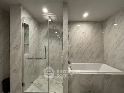 Luxurious marble bathroom with glass shower and built-in bathtub