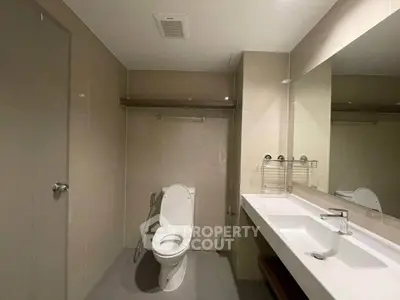 Modern bathroom with sleek fixtures and large mirror in a contemporary apartment.