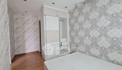 Modern bedroom with stylish wallpaper and sleek wardrobe design