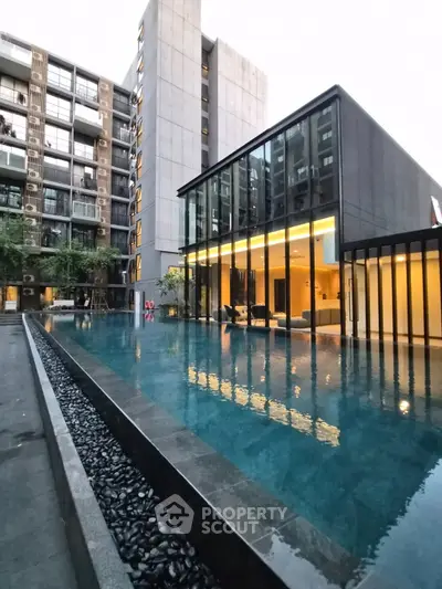 Luxurious modern apartment complex with stunning pool and sleek architecture.