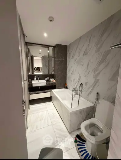 Modern bathroom with elegant marble tiles and sleek fixtures in a contemporary apartment.