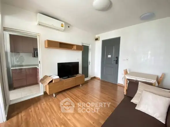Modern living room with wooden flooring and sleek furniture in a cozy apartment.