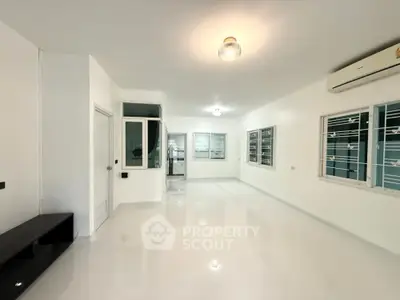 Spacious modern living room with white walls and large windows