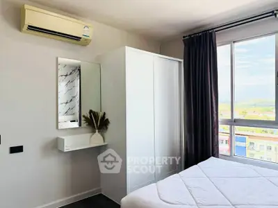 Modern bedroom with large window and air conditioning in a stylish apartment.