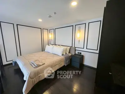 Luxurious modern bedroom with elegant wall paneling and cozy bedding in a stylish apartment.