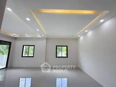 Spacious modern living room with recessed lighting and large windows