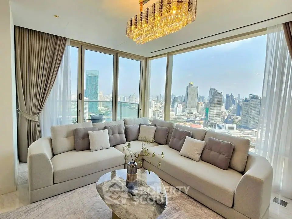 Luxurious living room with panoramic city view and elegant chandelier.