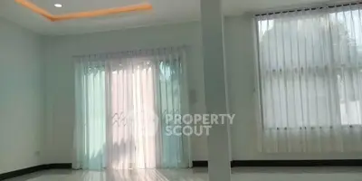 Spacious empty room with large windows and elegant curtains, perfect for customization.