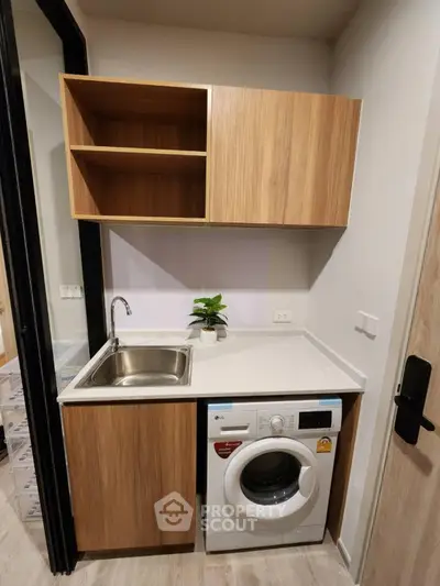 Compact modern kitchen with washing machine and wooden cabinetry