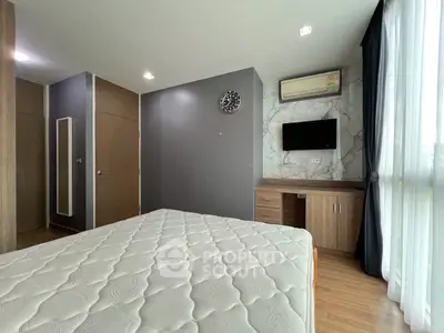 Modern bedroom with stylish decor, featuring a wall-mounted TV and air conditioning.