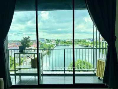 Stunning balcony view overlooking a serene river and cityscape, perfect for relaxation and enjoying nature.
